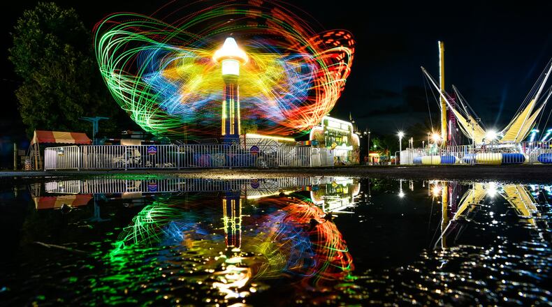 Light trails are visible from the rides in action at the Butler County Fair Monday, July 22, 2019 in Hamilton. NICK GRAHAM/STAFF