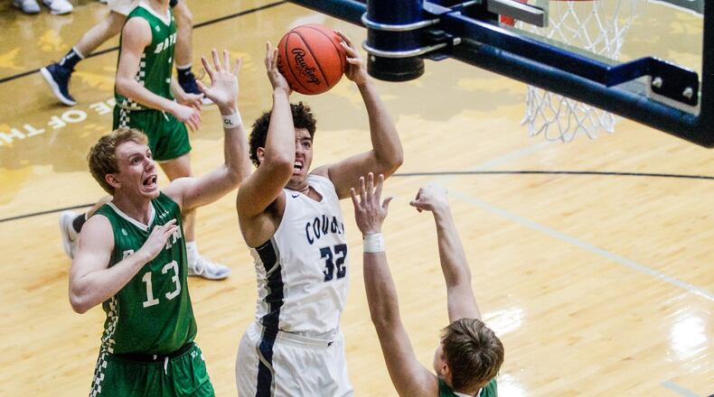 Edgewood’s Isaiah Gambrell puts up a shot defended by Badin’s Justin Pappas (13) and Nathan Hegemann (right) during Friday night’s game at Ron Kash Court in St. Clair Township. Badin won 49-46. NICK GRAHAM/STAFF