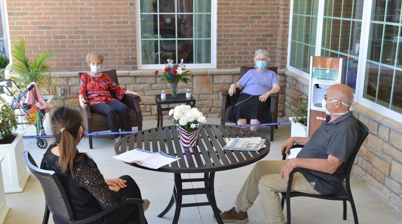 Randall Residence of Centerville residents and workers sit outside at the courtyard, where visitors will soon be able to meet with loved ones from a distance. CONTRIBUTED