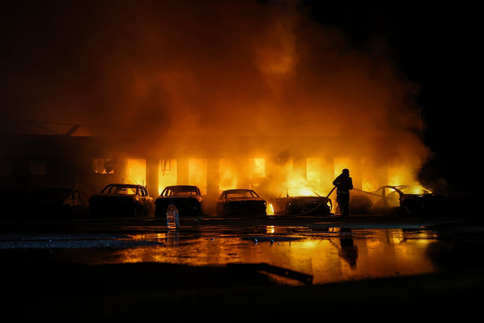 A rescue worker puts out a fire of cars destroyed by a Russian drone strike in Zaporizhzhia, Ukraine, on Wednesday, June 18, 2025. (AP Photo/Kateryna Klochko)