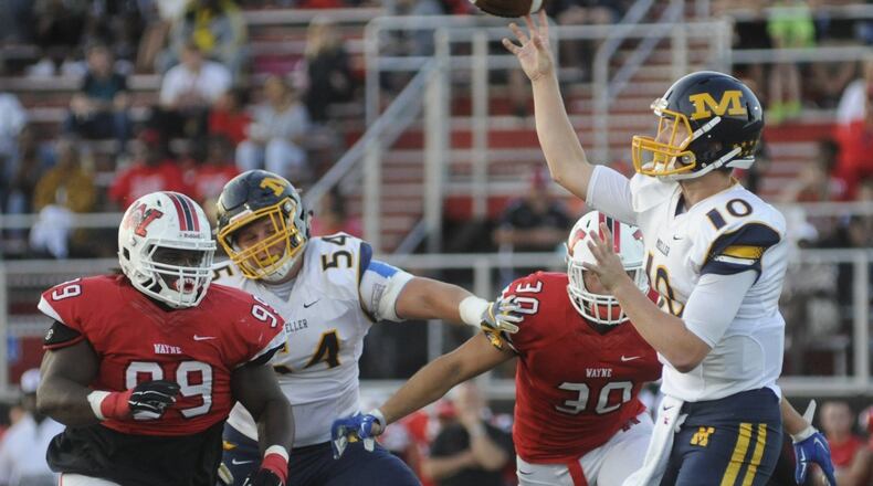 Wayne’s Mazon Walker (99) and Alex Reigelsperger close on Moeller QB Evan Ernst. Wayne hosted Moeller in a Week 2 high school football game at Heidkamp Stadium on Friday, Sept. 2, 2016. MARC PENDLETON / STAFF