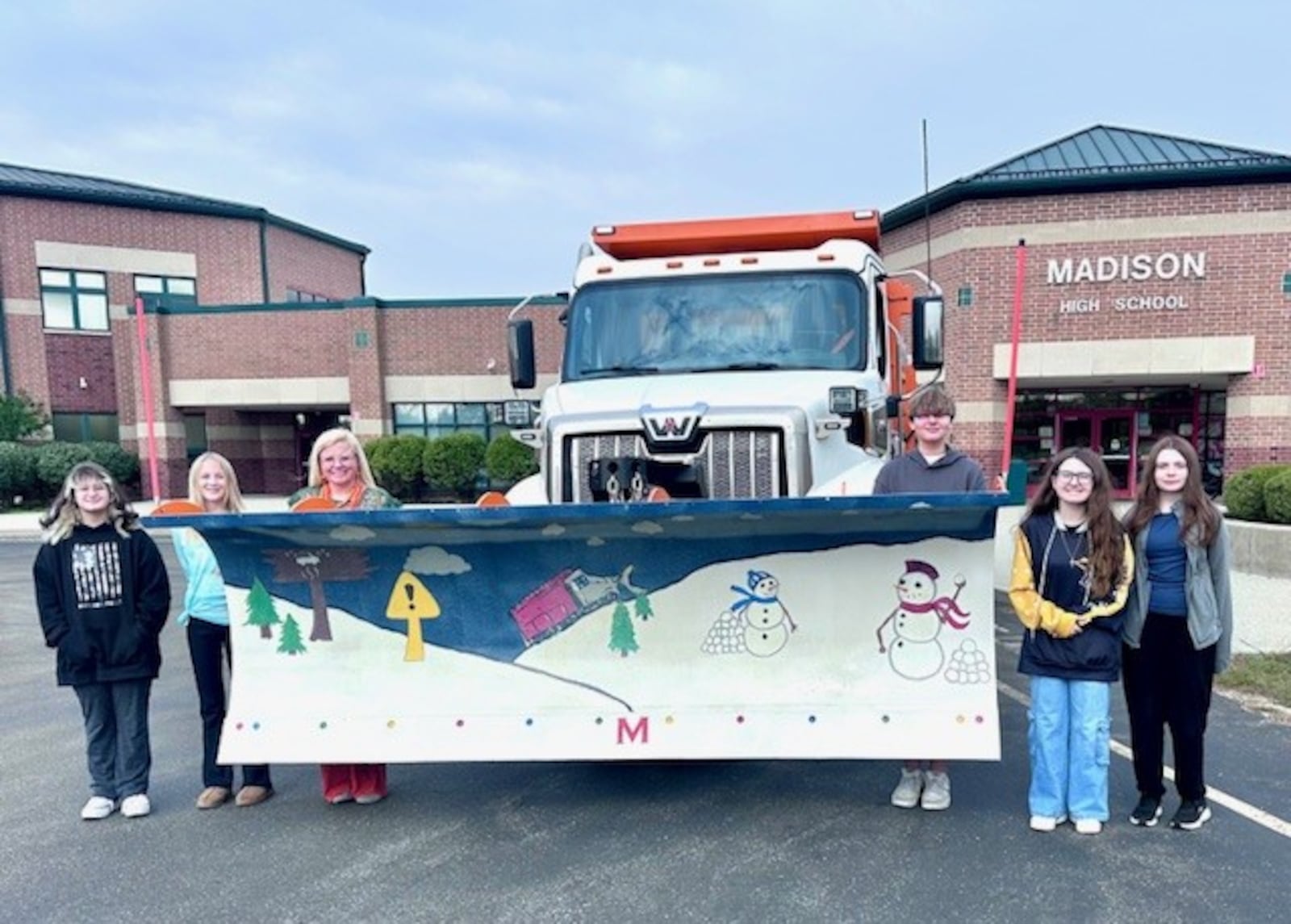 Students are seen here with Madison High School Teacher Chelsea Higgins. This group painted a snow plow blade to be used this winter by the Butler County Engineer's Office. BCEO/CONTRIBUTED