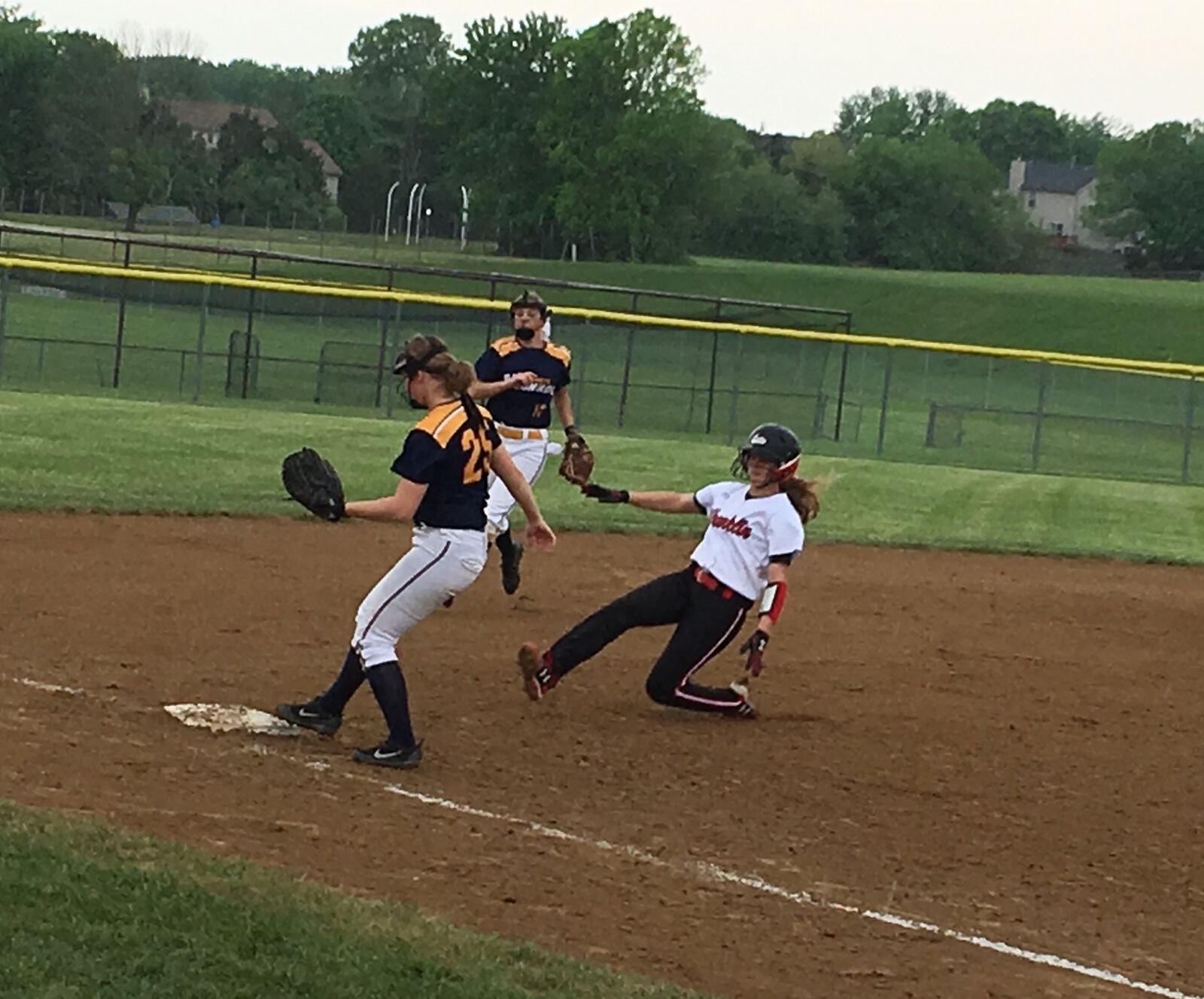 Monroe third baseman Sam Ross (25) steps on the bag for the game-ending out as Franklin’s Kristen Earles prepares to slide Wednesday in a Division II district semifinal at Lebanon. RICK CASSANO/STAFF