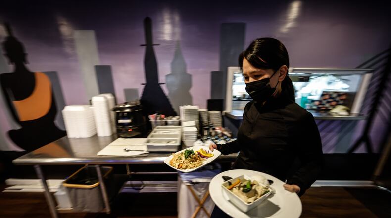 Thai Table manager, Pom Hmornvattanavong, serves food March 14, 2022. Two years ago, Ohio shut down bars and indoor dining for two-and-a-half months in hopes of stopping the spread of COVID-19. JIM NOELKER/STAFF
