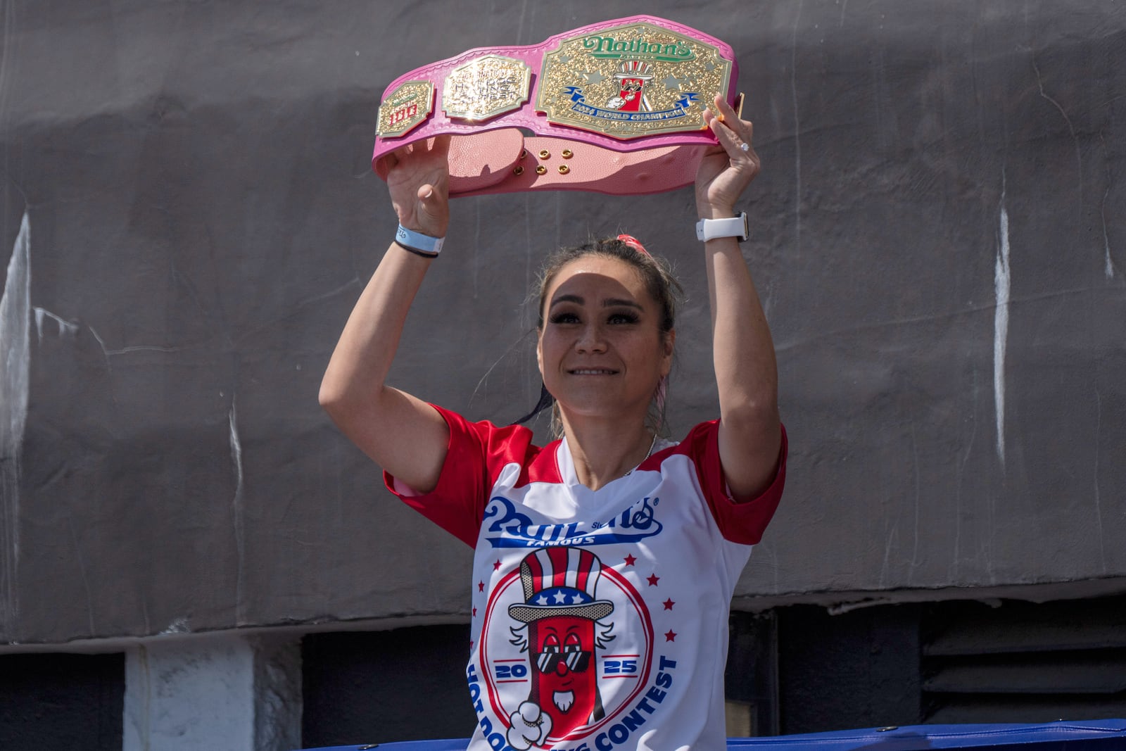 Competitive eater Miki Sudo raises a champion belt as she arrives at the 2025 Nathan's Famous Fourth of July hot dog eating contest in the Coney Island section of the Brooklyn borough of New York, Thursday, July 4, 2025. (AP Photo/Yuki Iwamura)