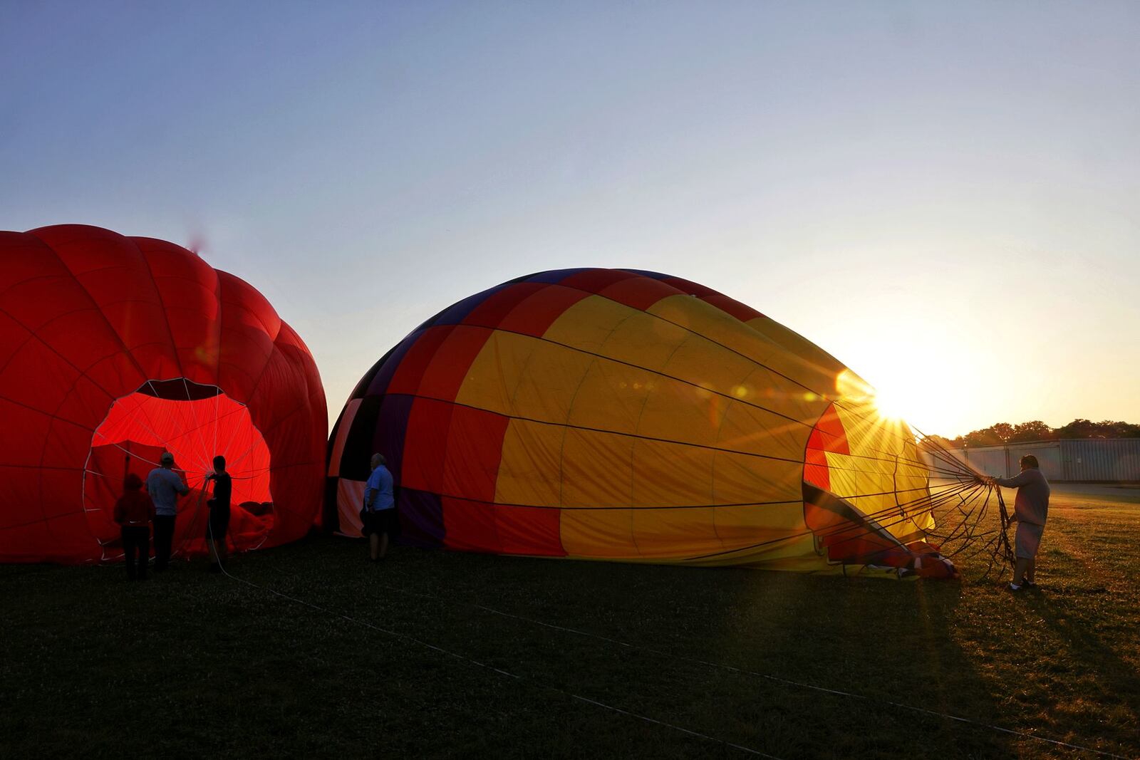 The Ohio Challenge hot air balloon festival is Friday and Saturday at Smith Park in Middletown. Crews deflate Sean Askren's DILLAGAF and Airheads balloons at Middletown Regional Airport/Hook Field during a preview Thursday morning, July 14, 2022. NICK GRAHAM/STAFF