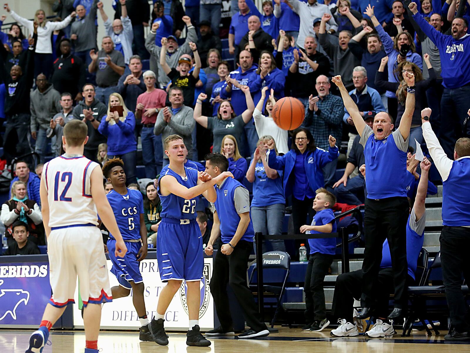 Cincinnati Christian celebrates in the final seconds of its 49-42 Division IV regional semifinal victory over New Madison Tri-Village on Tuesday night at Fairmont’s Trent Arena. That’s Daniel Nimmo (22) and Elijah Taylor (5) for CCS, along with assistant coach Brian Oates (jumping), while the Patriots’ Trey Frech (12) watches. CONTRIBUTED PHOTO BY E.L. HUBBARD