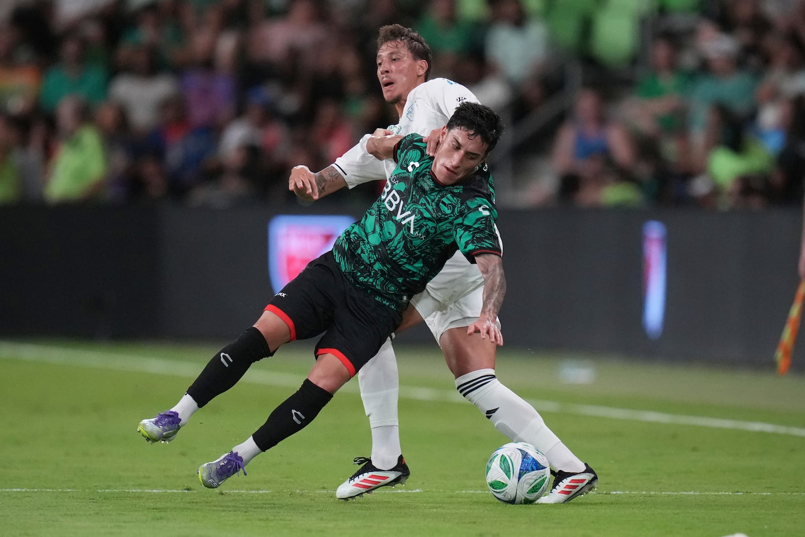 Liga MX All-Stars' Alejandro Zendejas, left, falls as he and MLS All-Stars' Guilherme Biro, right, compete for the ball during the MLS All-Star soccer match in Austin, Texas, Wednesday, July 23, 2025. (AP Photo/Eric Gay)