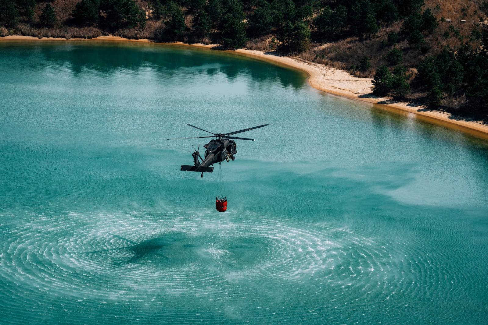 A helicopter picks up water to help battle a wildfire in Ocean County, N.J. on Thursday, April 24, 2025. (New Jersey Department of Environmental Protection via AP)