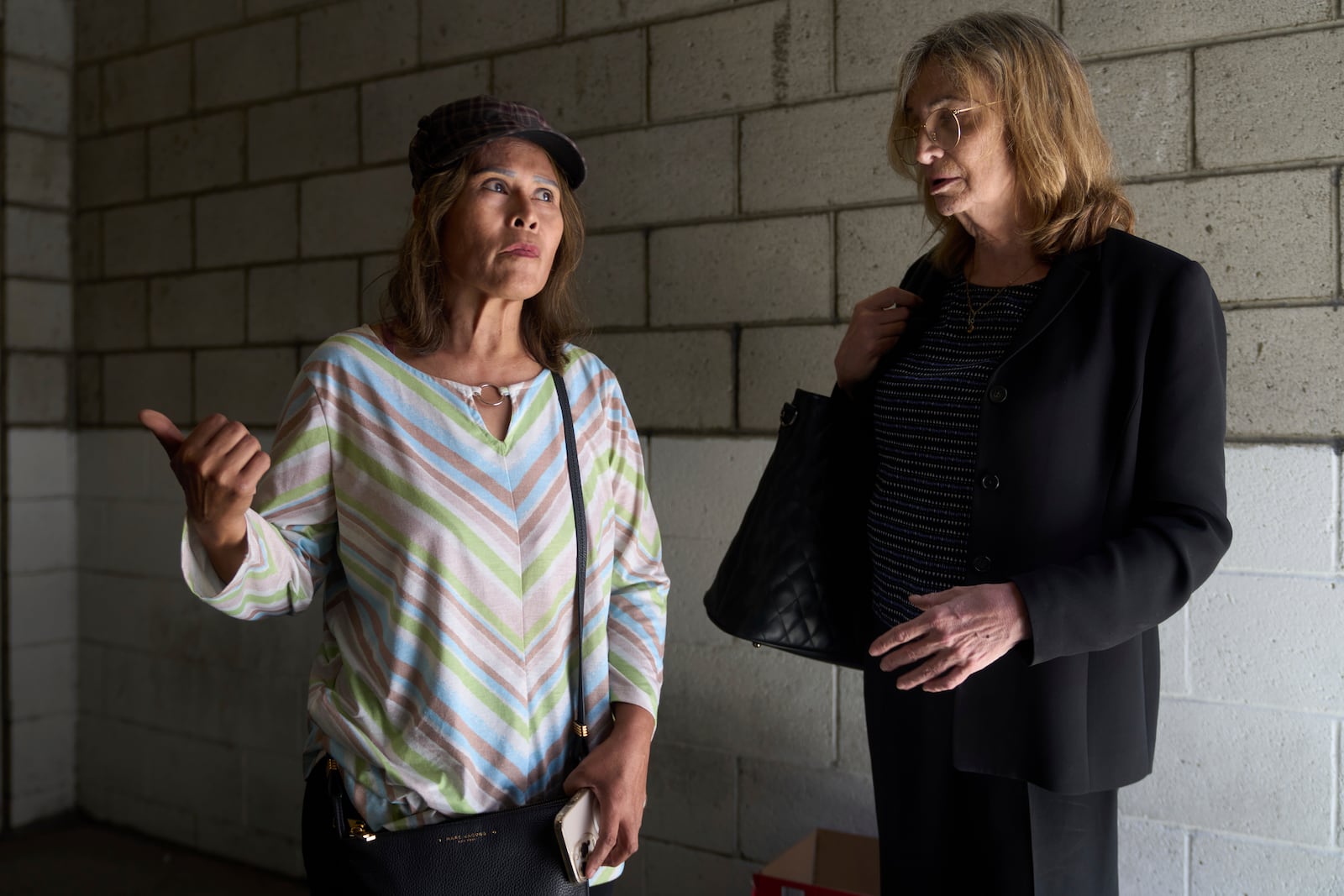 Som Xin, originally from Laos, inquires about hiring immigration Attorney Kim Carver as she exits the ICE Los Angeles Staging Facility, while trying to find her boyfriend's location after he was detained by federal agents in Los Angeles, on Wednesday, June 25, 2025. (AP Photo/Damian Dovarganes)