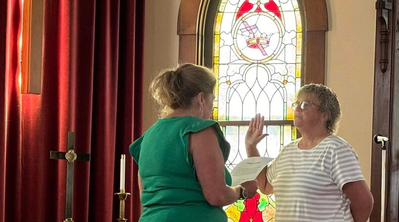 Seven Mile Mayor Melissa Mick, left, swears in Kathy Allen as the village's first female assistant fire chief during a ceremony at Seven Mile Presbyterian Church where Allen is a member. PROVIDED PHOTO