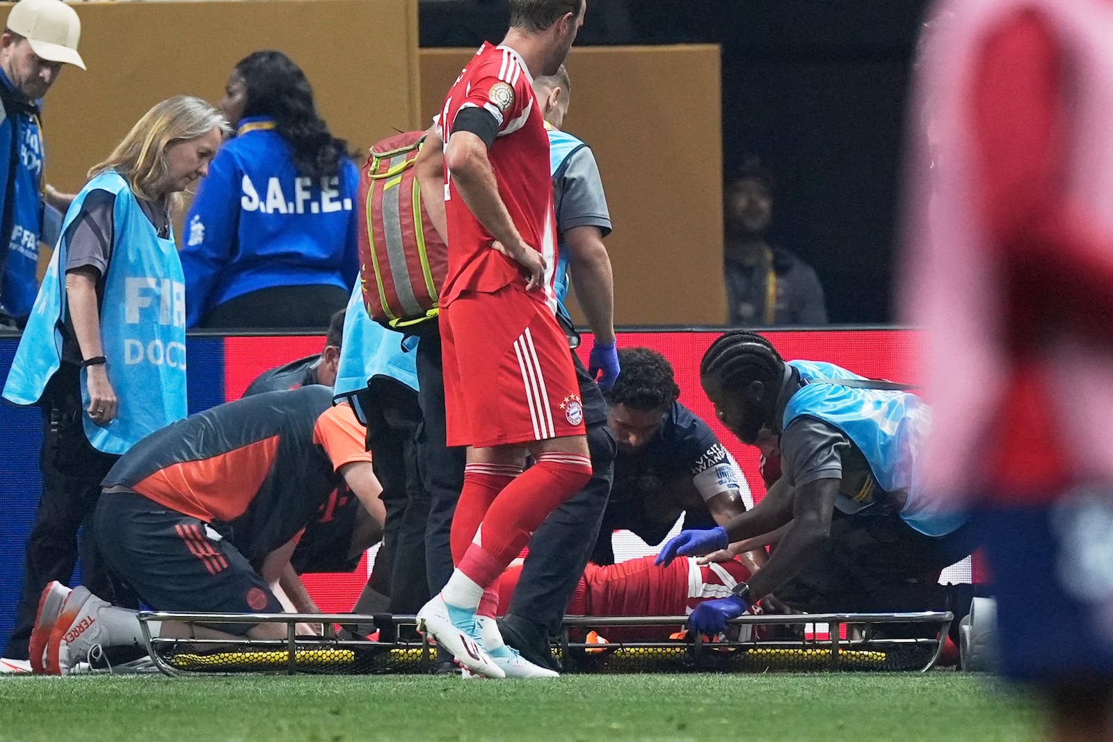 Bayern Munich's Harry Kane watches Bayern Munich's Jamal Musiala getting medical assistance during the Club World Cup quarterfinal soccer match between PSG and Bayern Munich in Atlanta, Saturday, July 5, 2025. (AP Photo/Mike Stewart)