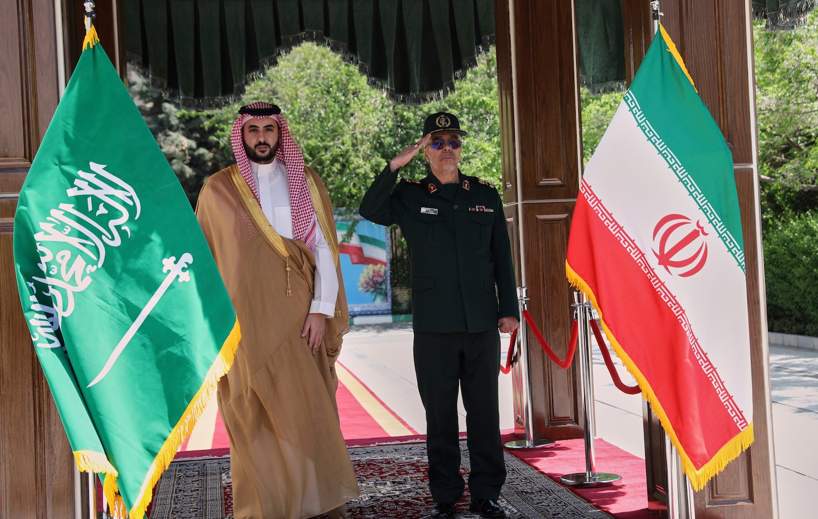 This image released by the public relations of the General Staff of Iran's Armed Forces, Saudi Arabia's Defense Minister Prince Khalid bin Salman, left, and Chief of the General Staff of Iran's Armed Forces Gen. Mohammad Hossein Bagheri listen to their countries national anthem during a welcoming ceremony for Prince Khalid bin Salman, in Tehran, Thursday, April 17, 2025. (Public relation of the General Staff of Iran's Armed Forces via AP)