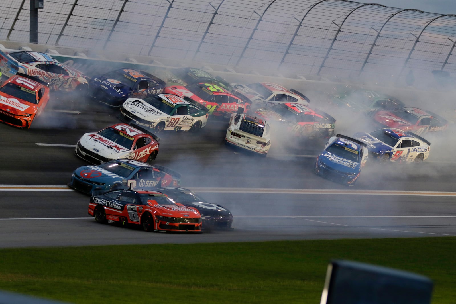 Twenty plus cars tangle up in turn three of lap sixty nine during a NASCAR Cup Series auto race, Saturday, June 28, 2025, in Hampton, Ga. (AP Photo/Russell Norris)