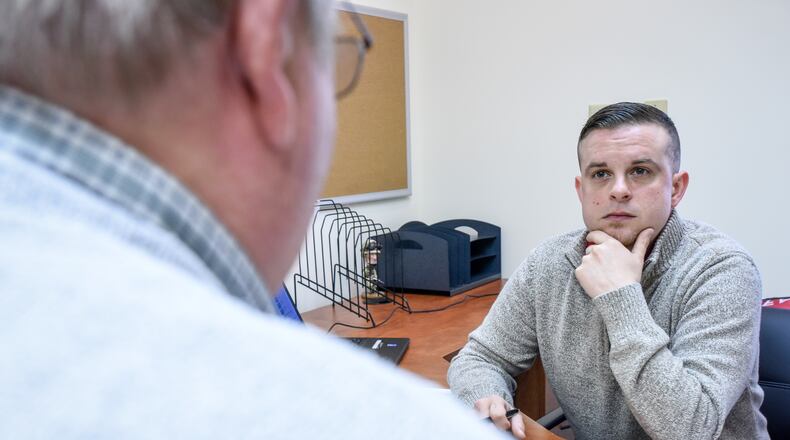 Casey James, right, service officer with the Butler County Veterans Service Commission, meets with a client in the Middletown branch office on Breiel Boulevard. The vet board will be closing the satellite office in favor of operating in the new normal digital world prompted by the pandemic. NICK GRAHAM/STAFF