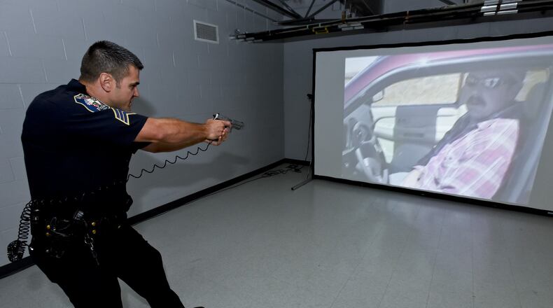In this 2015 photo, Sergeant Chris Whitton with West Chester Twp. Police Department demonstrates a training simulator used for threat assessment and decision making training in high stress environments. The simulator has a debrief function to allow the officer to explain the actions taken and show where and if the target was hit if the gun was discharged. The Fairfield Police Department plans to also begin using a similar simulator to train police officers. NICK GRAHAM/STAFF