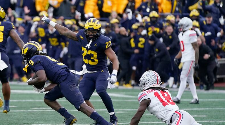 Michigan defensive back Rod Moore (9) intercepts a pass intended for Ohio State wide receiver Marvin Harrison Jr. (18) during the second half of an NCAA college football game, Saturday, Nov. 25, 2023, in Ann Arbor, Mich. (AP Photo/Carlos Osorio)