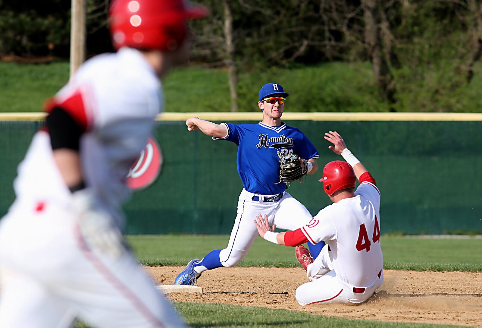 Hamilton second baseman Trace Thomas turns a 5-4-3 double play on Lakota West’s Dominic Schivone (44) and Michael Medley on Sunday at West. CONTRIBUTED PHOTO BY E.L. HUBBARD