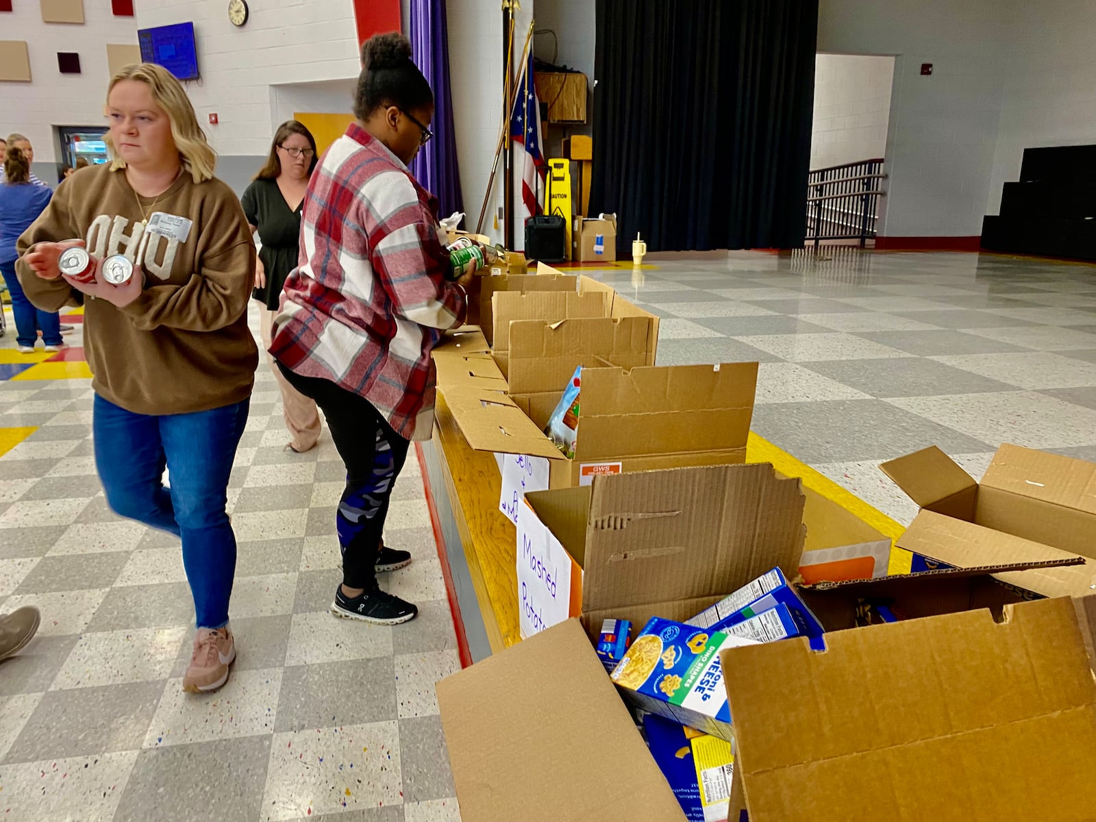 For more than a decade Middletown’s Central Elementary has made packing Thanksgiving meals and other items for needy local families a total school event.
The school’s annual “Turkey Pass” sees hundreds of the students line up in the school’s main hallway leading to the cafeteria and then each donated Thanksgiving food and care item is passed from one student’s hands to another. The food and items are then placed in customized boxes for families. (Photo By Michael D. Clark/Journal-News)
