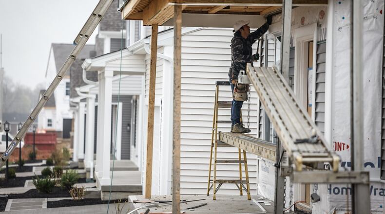 Nestor Uzhca hangs siding on a newly constructed house on Chamberlin Drive in Miamisburg on Wednesday, April 10, 2024. JIM NOELKER/STAFF