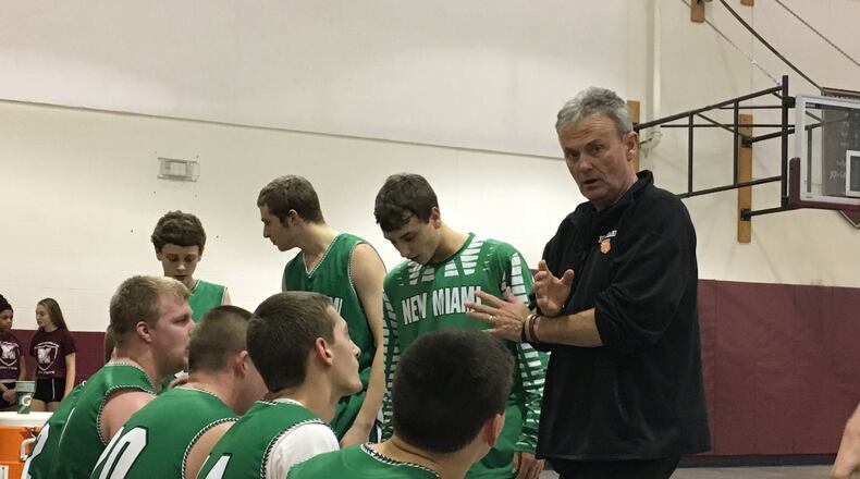 New Miami coach Dave Farrish talks to his team during a timeout Wednesday night at Mt. Auburn International Academy. Farrish’s Vikings posted a 63-34 victory. RICK CASSANO/STAFF