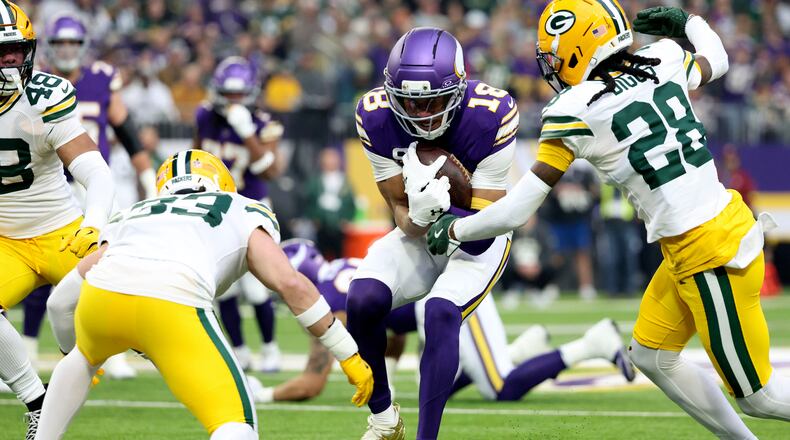 Minnesota Vikings wide receiver Justin Jefferson (18) is tackled by Green Bay Packers safety Evan Williams (33) and cornerback Trevon Diggs (28) after catching a pass during the first half of an NFL football game, Sunday, Jan. 4, 2026, in Minneapolis. (AP Photo/Ellen Schmidt)