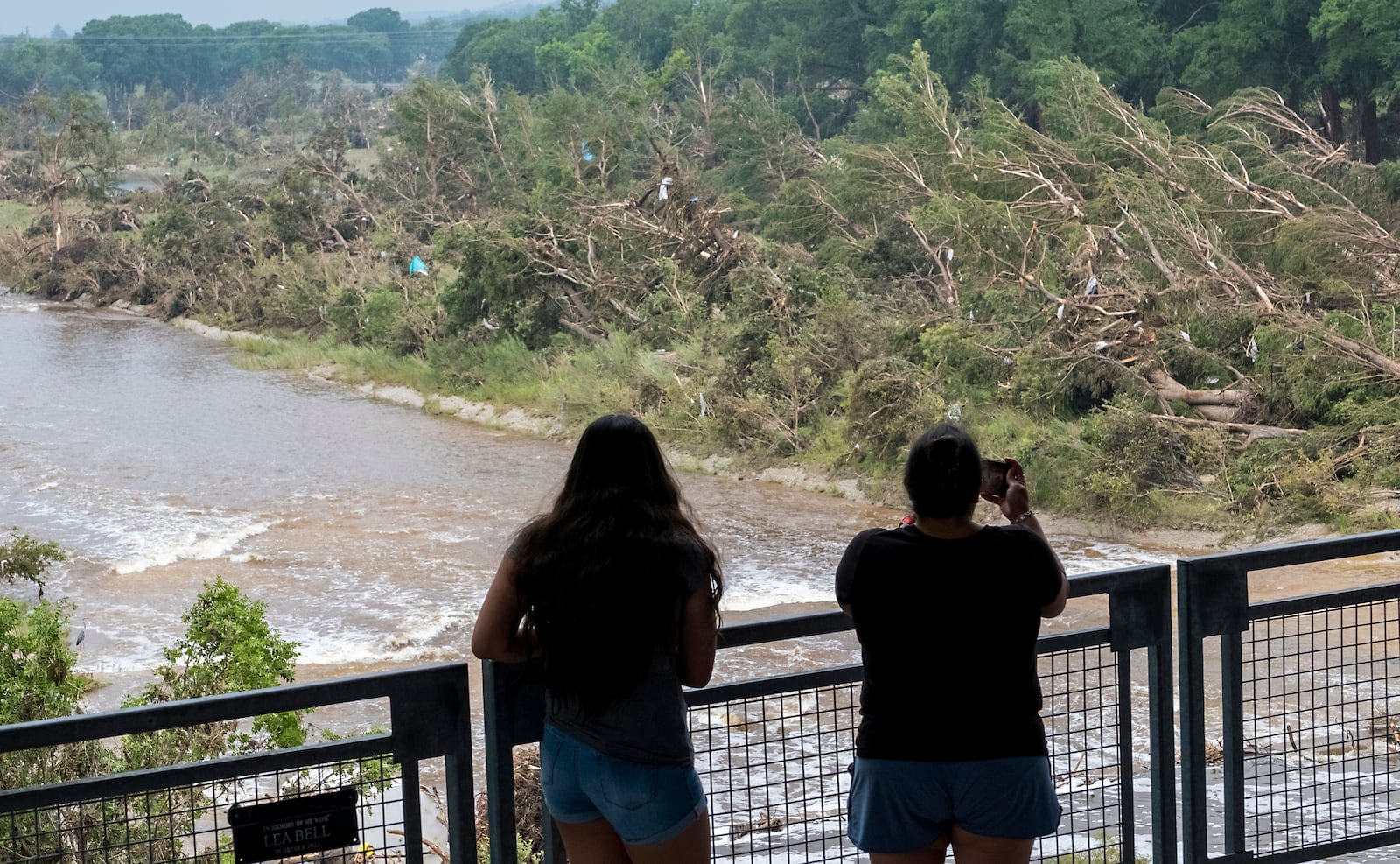 Onlookers review the damage along the Guadalupe River caused by recent flooding, Sunday, July 6, 2025, in Kerrville, Texas. (AP Photo/Rodolfo Gonzalez)