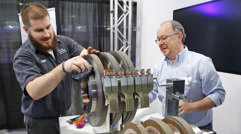 Manufacturing technician Adam Fox, left, and international sales representative Ralf Schuerl prepare centerless grinding machine parts for display at United Grinding in this photo from April 2018. TY GREENLEES / STAFF
