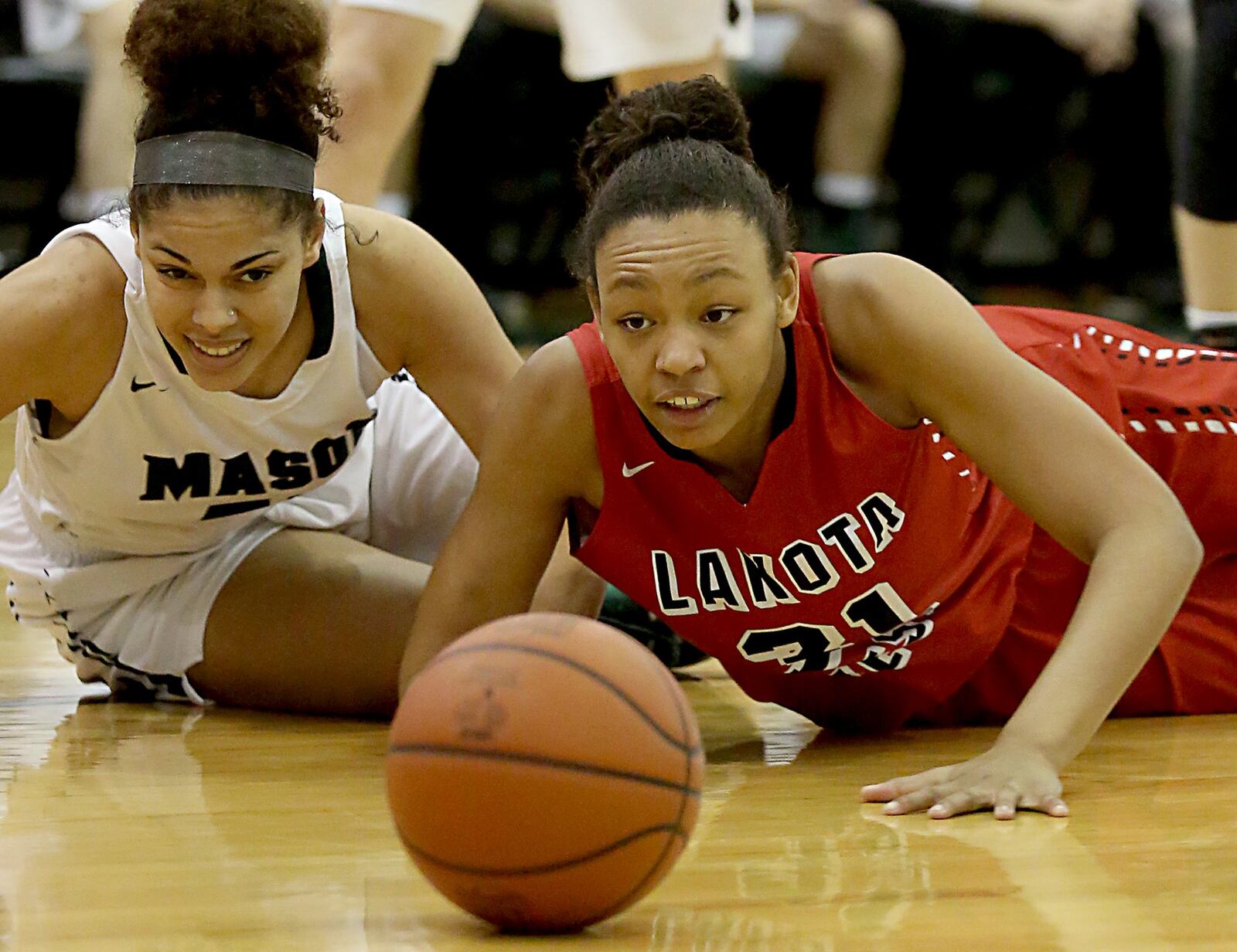 Mason’s Ti Fulton and Lakota West’s Nevaeh Dean (right) watch the ball roll out of bounds during their basketball game at Mason on Jan. 28, 2017. CONTRIBUTED PHOTO BY E.L. HUBBARD