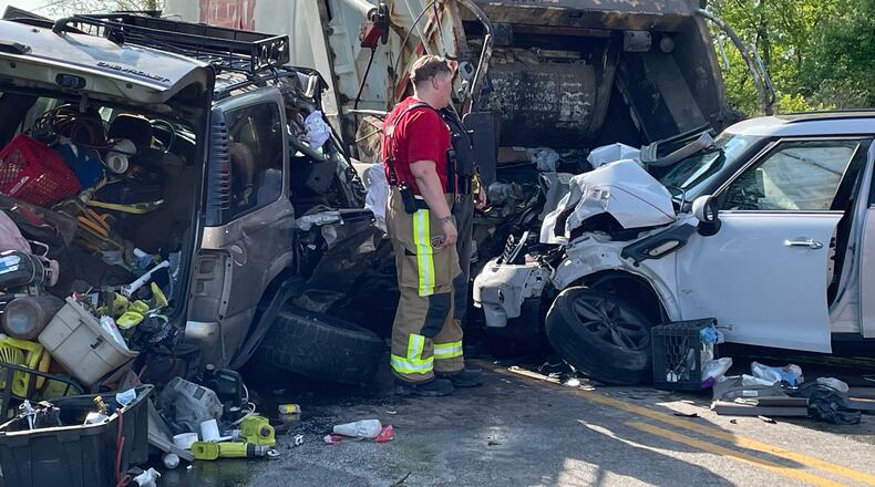 A Rumpke garbage truck was stopped to pick up trash on West County Line Road when it was struck from behind by a Chevrolet Tahoe and a Mini Cooper Friday May 13, 2022. BILL LACKEY/STAFF