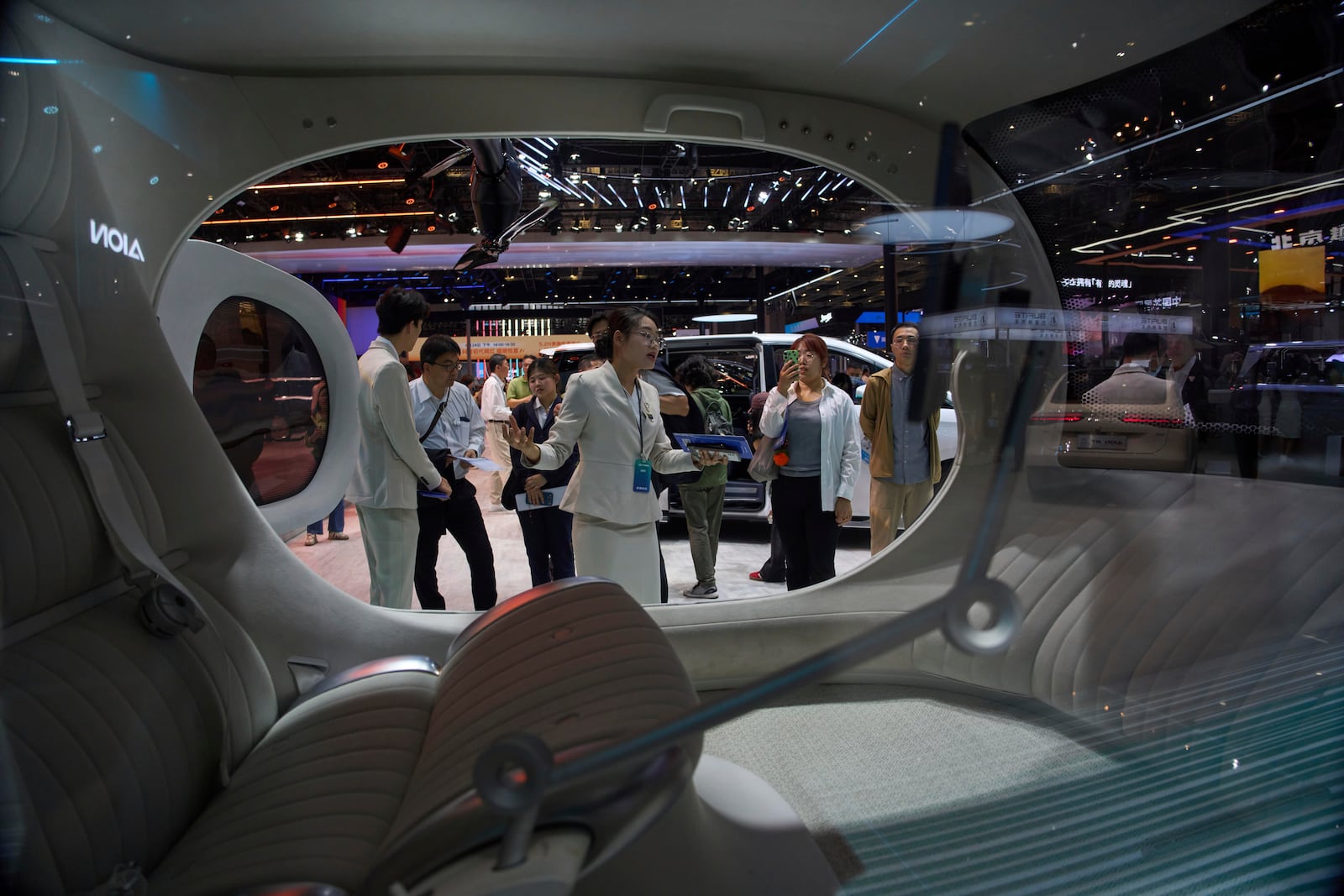 A worker introduces GOVY Air Car from GAC Group displayed at the Shanghai auto show on Thursday, April 24, 2025. (AP Photo/Ng Han Guan)