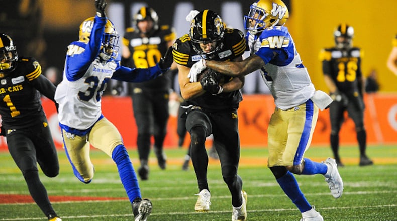 CALGARY, AB - NOVEMBER 24: Jaelon Acklin #80 of the Hamilton Tiger-Cats runs the ball against Brandon Alexander #37 (R) and Winston Rose #30 of the Winnipeg Blue Bombers during the 107th Grey Cup Championship Game at McMahon Stadium on November 24, 2019 in Calgary, Alberta, Canada. (Photo by Derek Leung/Getty Images)