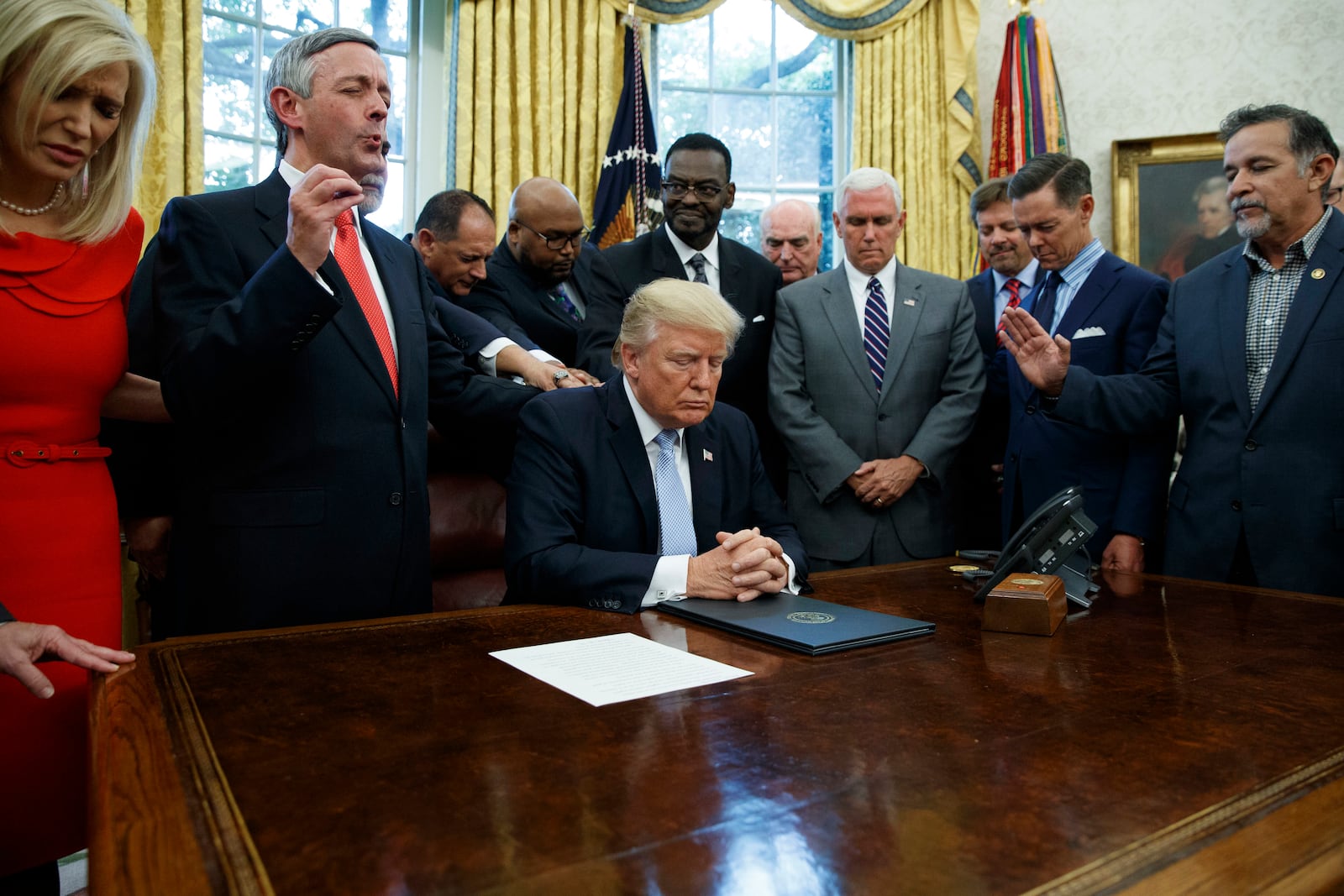 FILE - Religious leaders pray with President Donald Trump Sept. 1, 2017, after he signed a proclamation for a national day of prayer to occur on Sept. 3, 2017, in the Oval Office of the White House in Washington. (AP Photo/Evan Vucci, File)