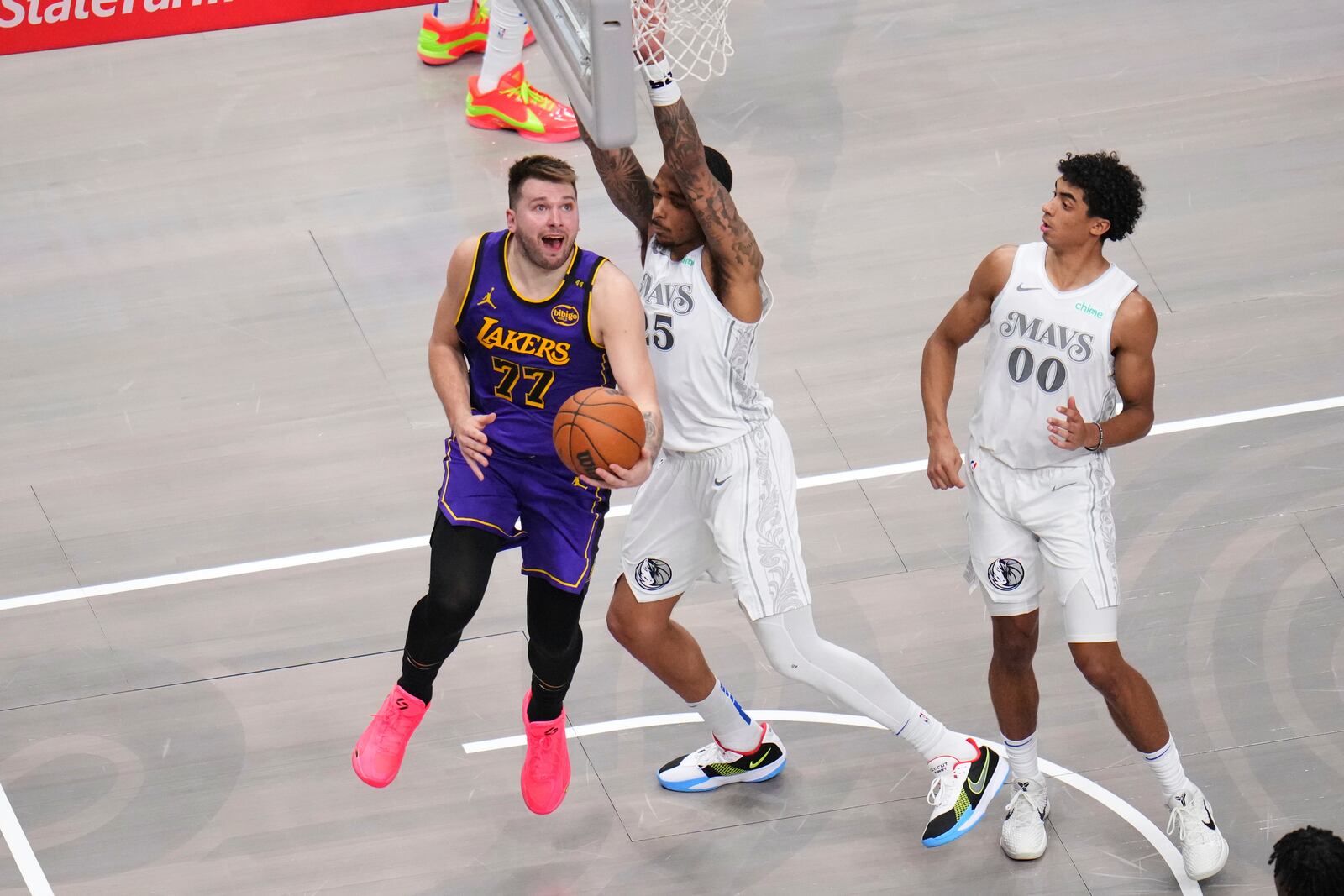 Los Angeles Lakers' Luka Doncic (77) shoots as Dallas Mavericks' P.J. Washington (25) and Max Christie (00) defend in the second half of an NBA basketball game in Dallas, Wednesday, April 9, 2025. (AP Photo/Julio Cortez)