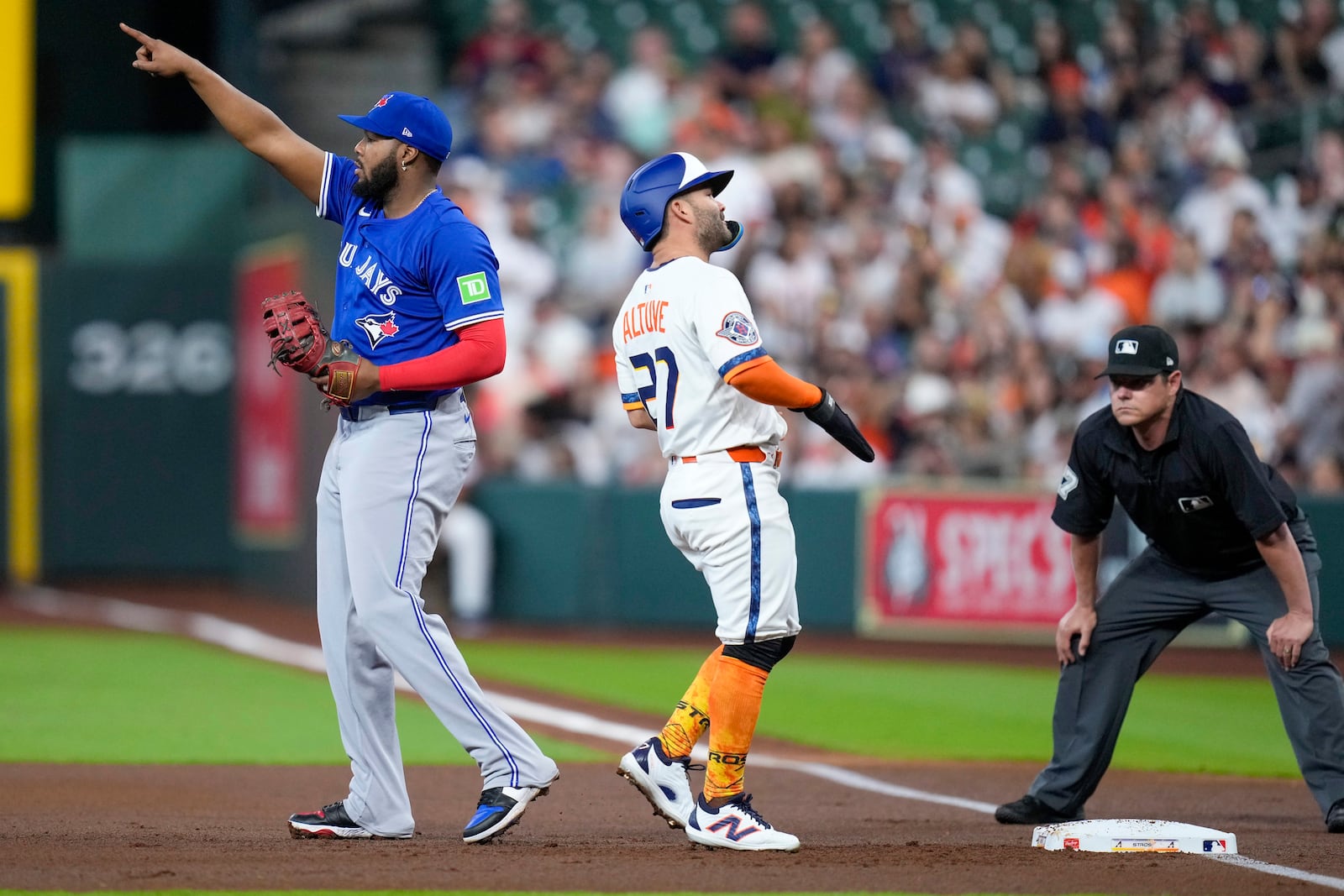 Toronto Blue Jays first baseman Vladimir Guerrero Jr., left, points to left fielder Alan Roden after Guerrero Jr. completed a double play off Houston Astros' Jose Altuve, center, during the first inning of a baseball game Monday, April 21, 2025, in Houston. (AP Photo/Eric Christian Smith)