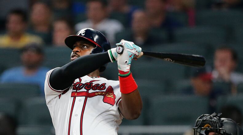 Atlanta Braves’ Brandon Phillips (4) follows through on a two-run home run as Pittsburgh Pirates catcher Francisco Cervelli (29) looks on in the third inning of a baseball game, Monday, May 22, 2017, in Atlanta. (AP Photo/John Bazemore)