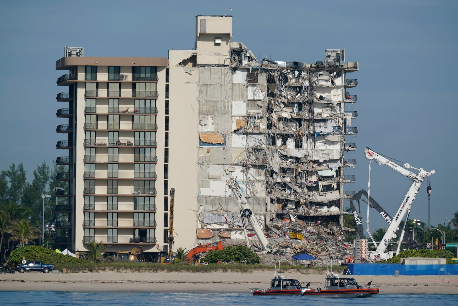 FILE - Coast Guard boats patrol in front of the partially collapsed Champlain Towers South condo building in Surfside, Fla., on July 1, 2021. (AP Photo/Mark Humphrey, File)