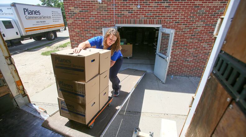 Planes Moving and Storage, which started with a single truck in downtown Cincinnati in 1921, is now in its third generation of leadership. It has earned a recurring spot on the Deloitte Cincinnati USA Top 100 Privately Owned Companies for the last 20 years. Pictured here are crews from Planes Moving and Storage removing items from the old Fairfield Central in 2017 prior to the building’s demolition. GREG LYNCH/FILE