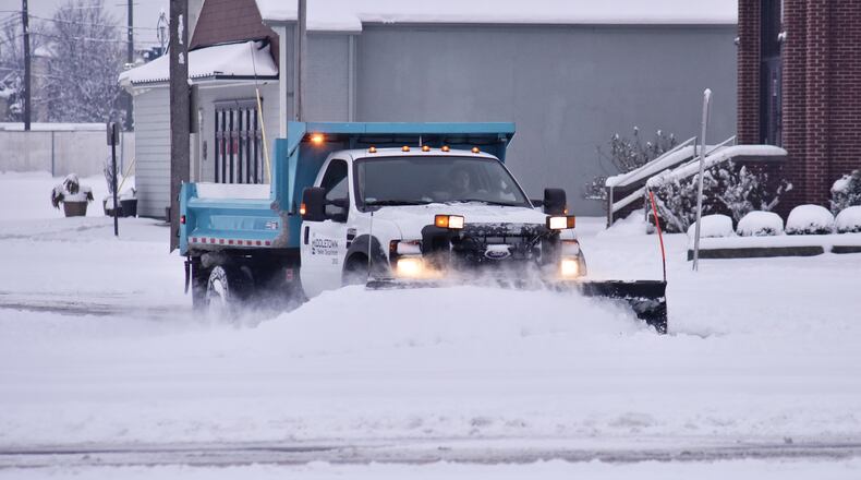 A city snow plow clears roads in Middletown. Snow blanketed Butler County causing slick roads and school closings. NICK GRAHAM / STAFF