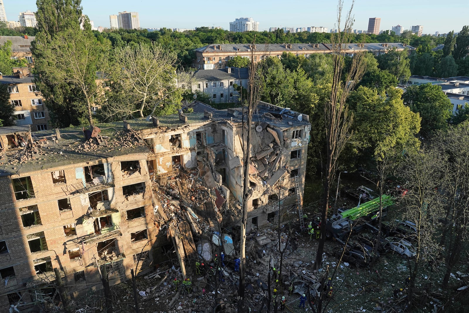 Firefighters work in a destroyed apartment building after a Russian attack in Kyiv, Ukraine, early Monday, June 23, 2025. (AP Photo/Efrem Lukatsky)