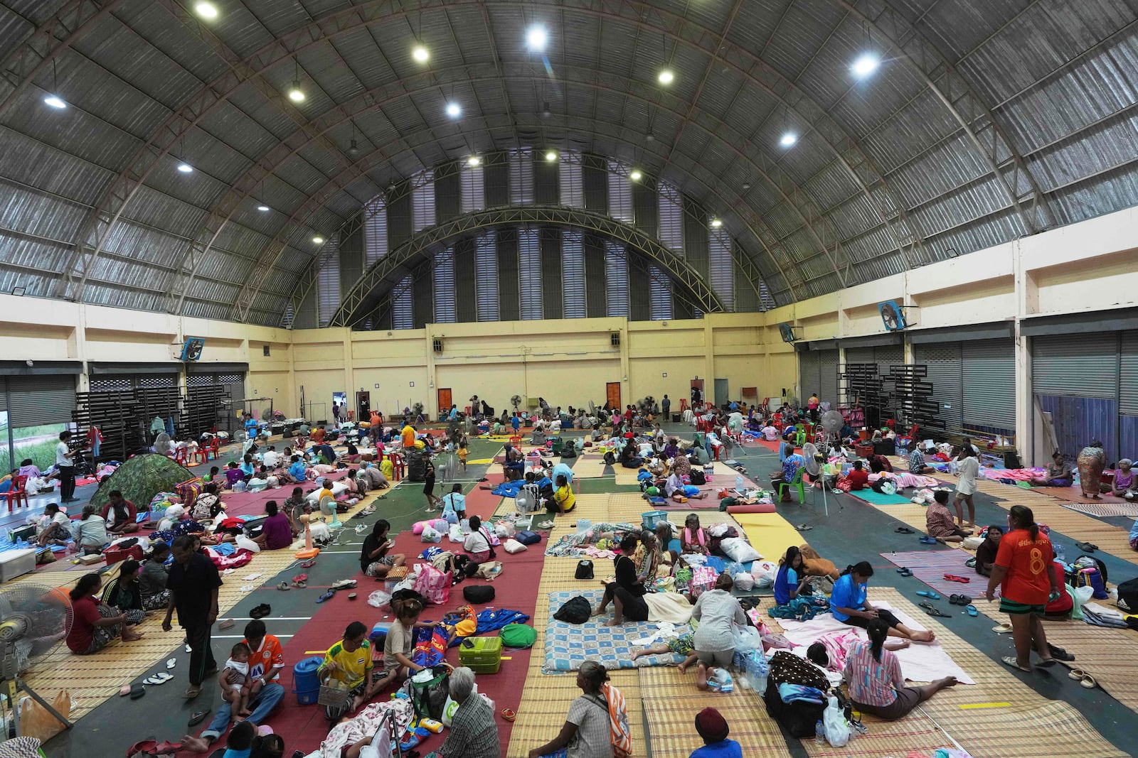 Thai residents who fled homes following clashes between Thai and Cambodian soldiers rest at an evacuation center in Surin province, Thailand, Friday, July 25, 2025. (AP Photo/Sakchai Lalit)