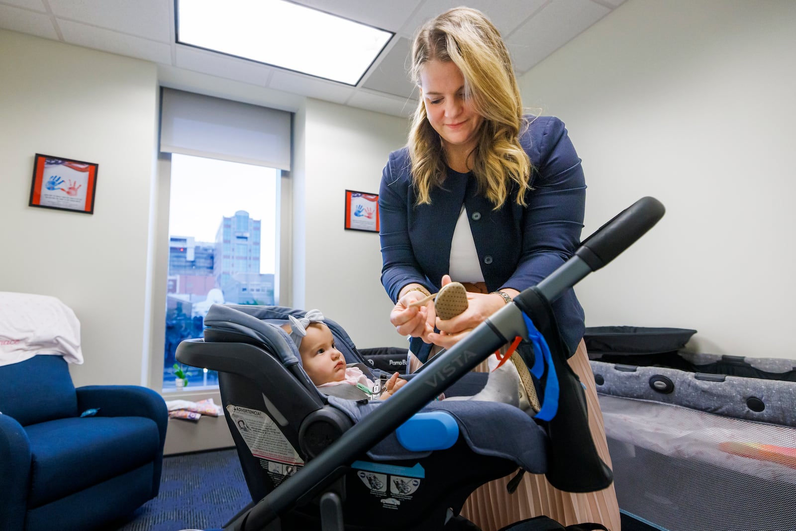 Florida Rep. Fiona McFarland, R-Sarasota, adjusts the shoe of her 7-month-old daughter Grace Melton as she starts her work day at the state Capitol, Thursday, April 17, 2025, in Tallahassee, Fla. (AP Photo/Colin Hackley)
