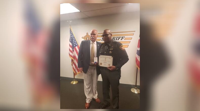 Butler County Sheriff Richard Jones presents Deputy Jody Green with a life-saving award for his quick action to help a choking student. SUBMITTED