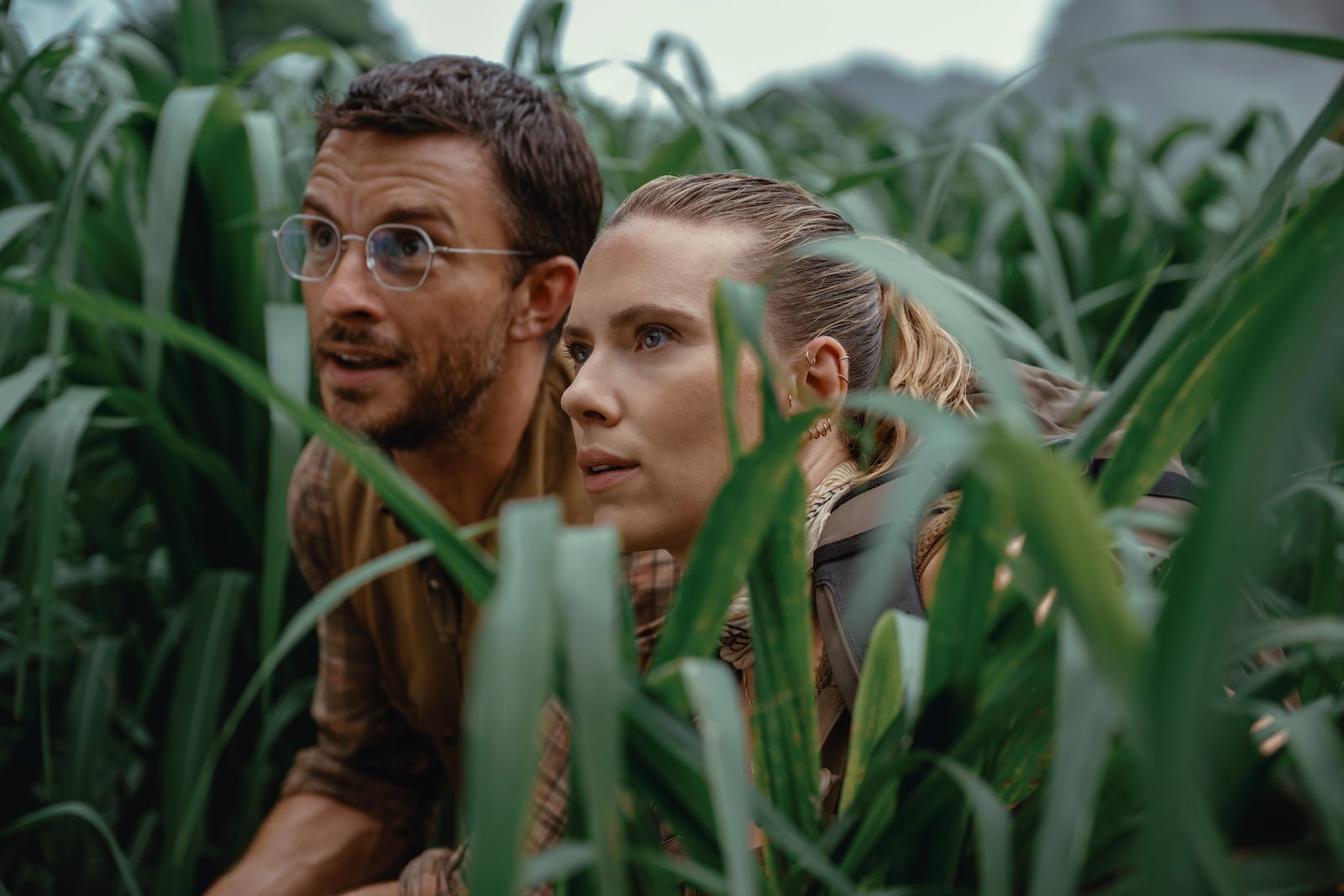 This image released by Universal Pictures and Amblin Entertainment shows Jonathan Bailey, Left, and and Scarlett Johansson in a scene from " Jurassic World: Rebirth." (Universal Pictures and Amblin Entertainment via AP)