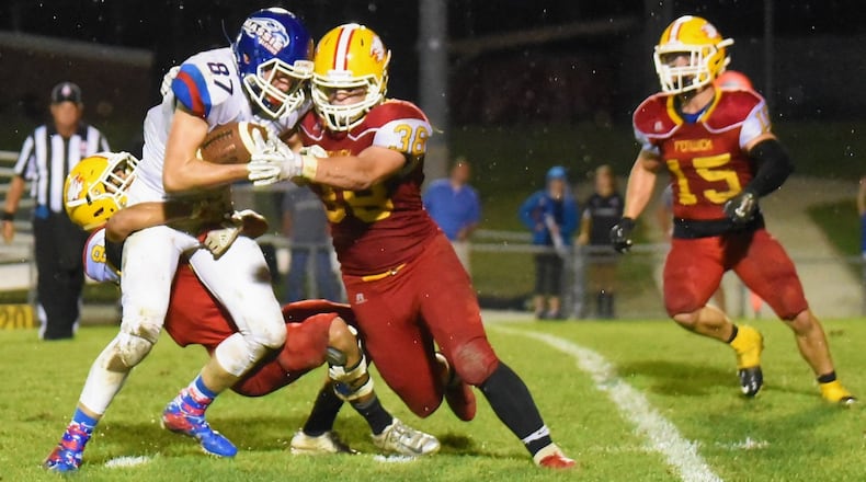 Fenwick’s Gio DiGirolamo (8), John Stevenson (38) and Henry Nenni (15) are part of a group effort in trying to bring down Clinton-Massie’s Griffin Laake (87) on Friday night at Krusling Field in Middletown. Massie took a 21-18 victory. CONTRIBUTED PHOTO BY ANGIE MOHRHAUS