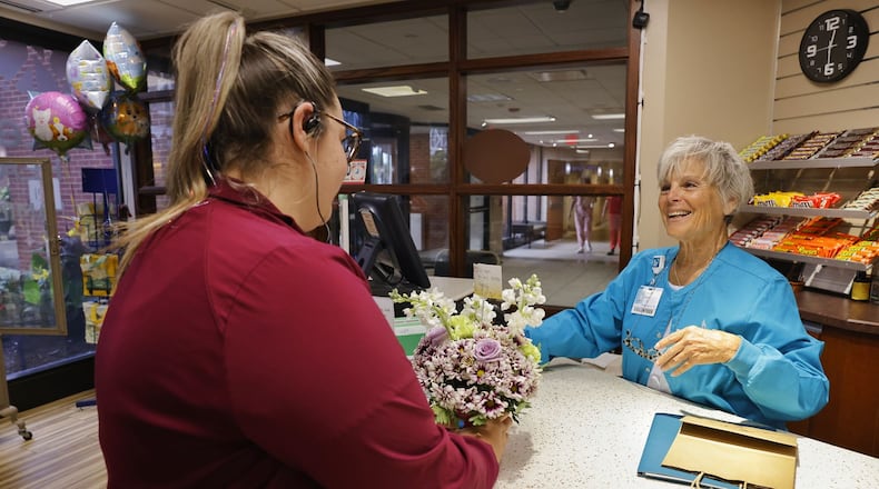 Health unit coordinator Miranda Meade, left, purchases flowers for a patient from hospital volunteer Cheryl Vajda at the gift shop Wednesday, July 10, 2024 at Kettering Health Hamilton. The gift was purchased through a new program funded by Fort Hamilton Hospital Foundation to allow employees to purchase gifts for patients. NICK GRAHAM/STAFF