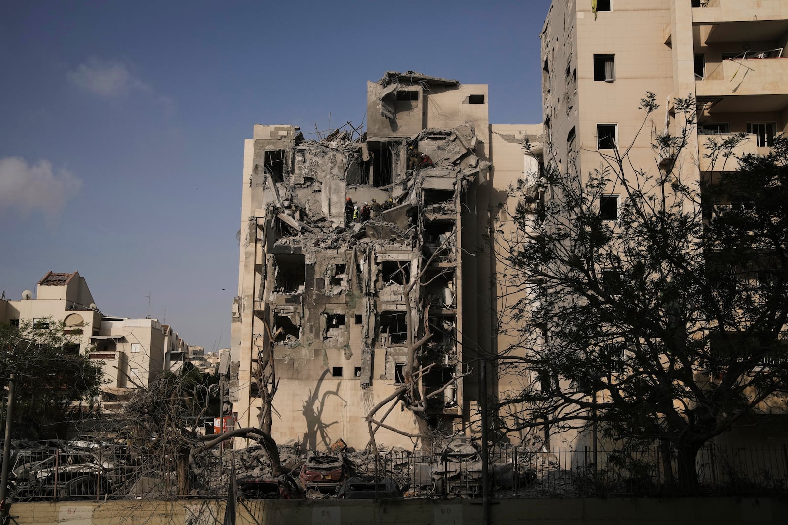 Israeli soldiers and a rescue team search for survivors amid the rubble of residential buildings destroyed by an Iranian missile strike that killed several people, in Beersheba, Israel, on Tuesday, June 24, 2025. (AP Photo/Leo Correa)