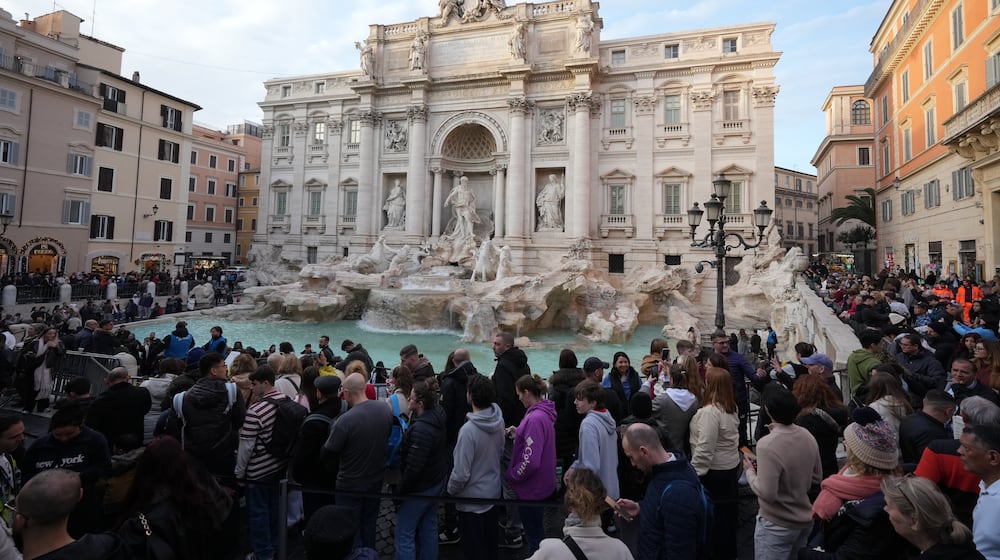 Visitors admire Rome's Trevi Fountain, Friday, Dec. 19, 2025, as the city municipality announced that, starting on Feb. 1, it will impose a 2 euro fee for tourists to visit the recessed fountain edge. (AP Photo/Andrew Medichini)