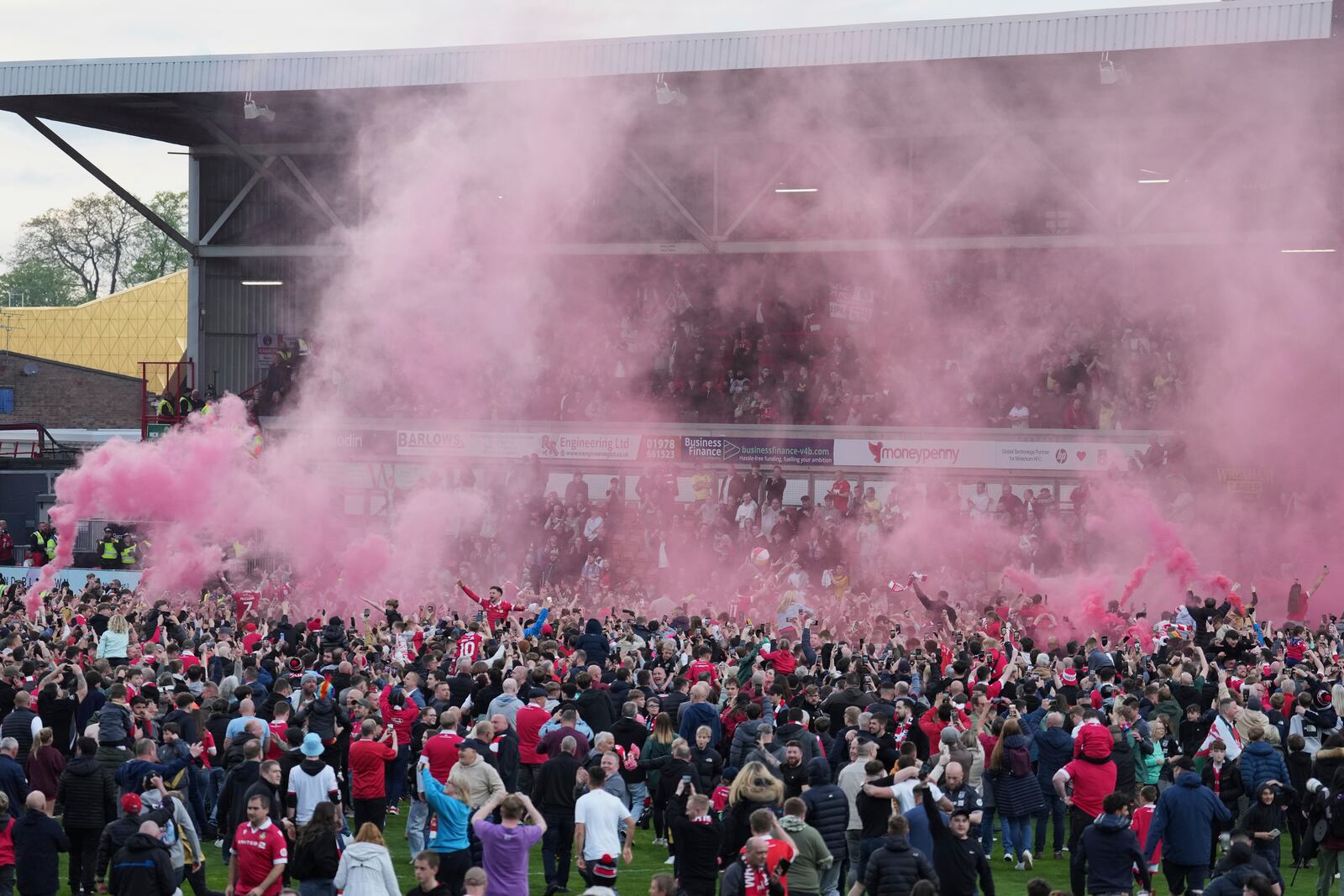 Wrexham players celebrate with fans as they win the English League One soccer match between Wrexham and Charlton Athletic at the Racecourse ground in Wrexham, Wales, Saturday, April 26, 2025. (AP Photo/Jon Super)