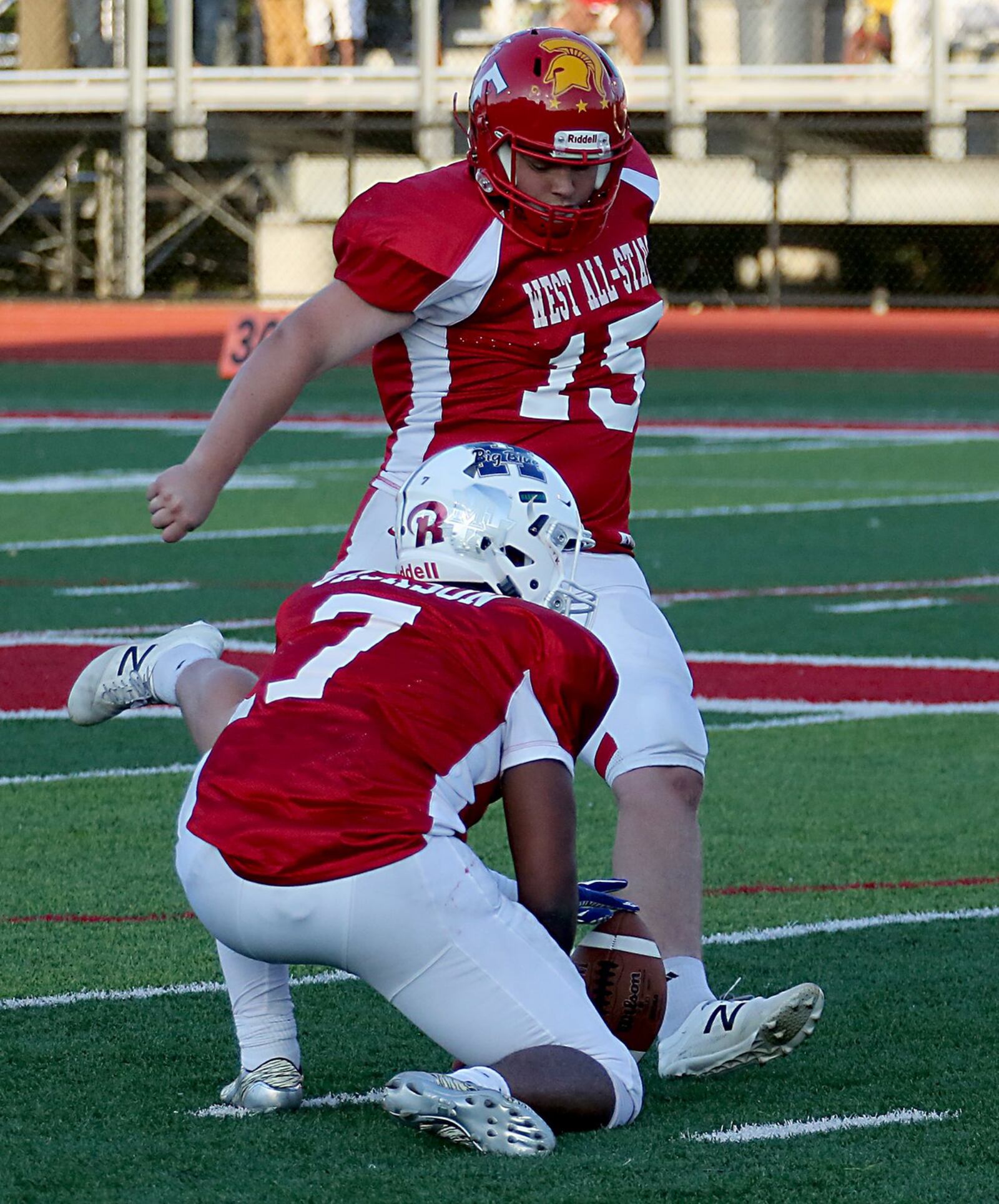 Hamilton’s Eric Jackson holds the ball for Fairfield’s Jerred McGuire on a West field-goal attempt Thursday night during the Southwestern Ohio Football Coaches Association Ron Woyan East-West All-Star Game at Kings. CONTRIBUTED PHOTO BY E.L. HUBBARD